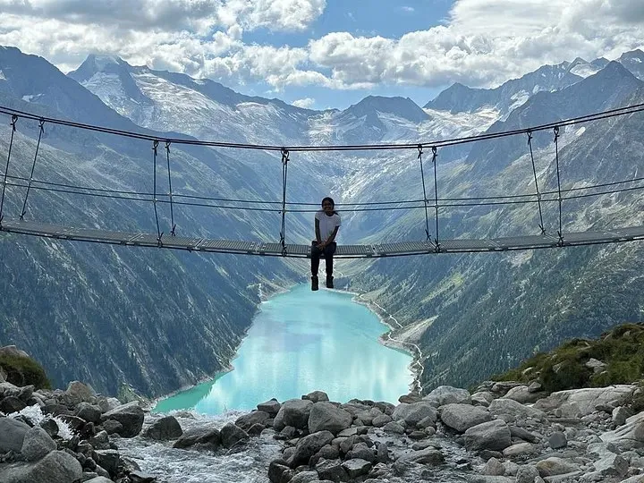 Ananya sitting on the suspension bridge above the turquoise reservoir