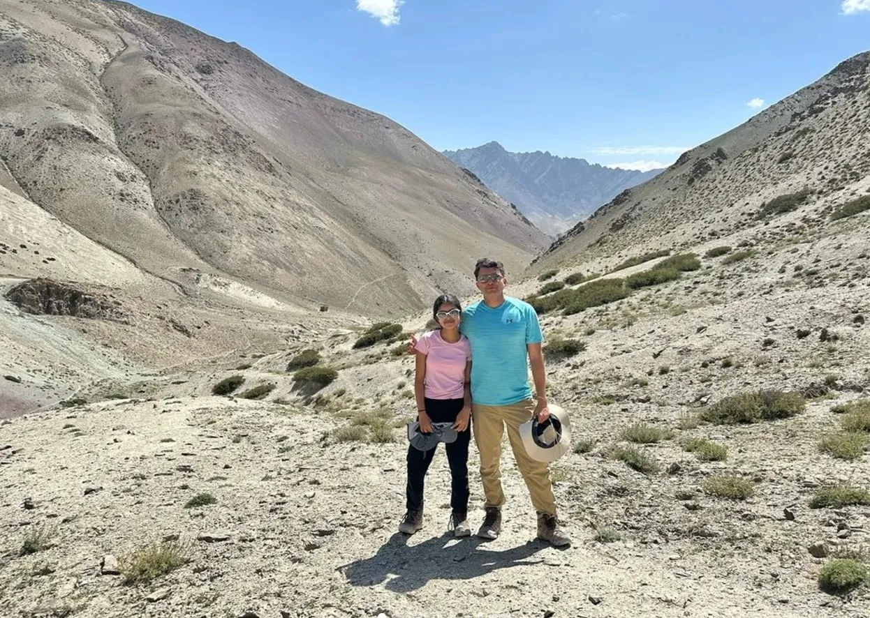 Ananya and her father standing in a high valley at 14,550 feet