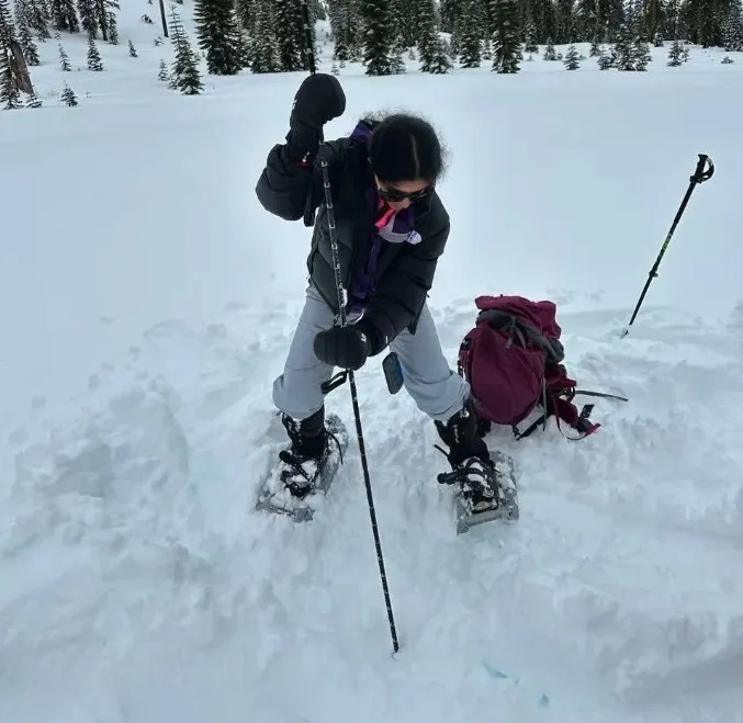 Ananya driving an avalanche probe into the snow